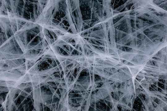 From above of frozen Lake Baikal surface with chaotic pattern and cracks as abstract background