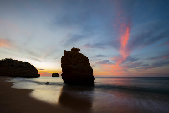 Spectacular view of big rock formation in the middle of the beach at Praia Da Marinha under sunste sky in Lagoa, Algarve Portugal