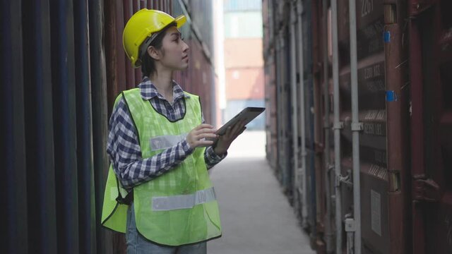 Professional industry worker of logistic concept.Engineer or foreman control loading Containers box from Cargo freight ship for import export,Engineer worker checking quantity of product in containers