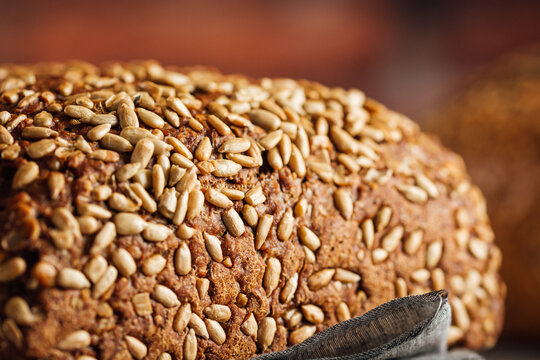 Delicious wholegrain bread on cutting board on table