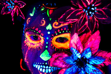 Anonymous female in multicolored masquerade mask with flowers on head looking at camera on Halloween night