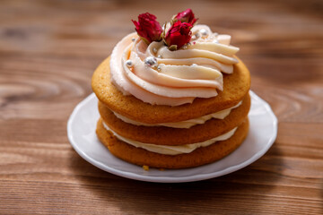 Obraz na płótnie Canvas Sponge cake with cream, decorated with small flowers.