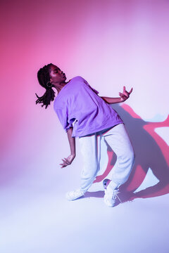 Full Body Of African American Teen Girl Performing Urban Dance Movement In Bright Studio