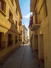 Obraz premium Calle estrecha con fachadas encaladas que parecen de color dorado por el sol del atardecer