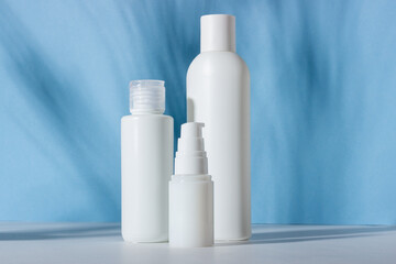 Set of white cosmetic bottles and jars with hard shadows. Home and beauty salon care concept