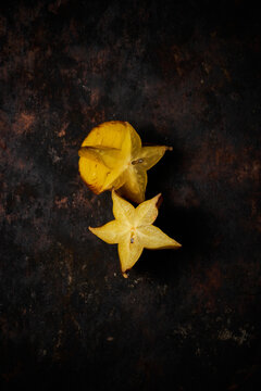 Top view of a carambola cut in half on rustic wooden background