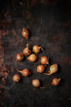 Top view of group of onions on dark rustic wooden background
