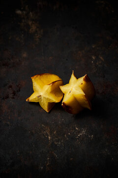 Top view of a carambola cut in half on rustic wooden background