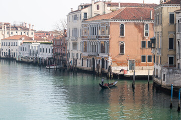 Fototapeta na wymiar Venice. Italy. February 2021. View of the Grand Canal in Venice. A gondola floats along the canal and the gondolier controls the boat. The concept of tourism, travel