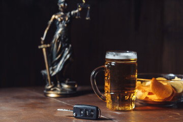 Drunk driving concept. Lady of justice, glass of beer and car key.