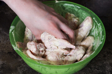 Hand spices meat. Chicken meat in sauce or marinade. Chicken wings