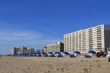 Crédence de cuisine en verre imprimé Descente vers la plage row of blue umbrella beaches lined up in the sandy beaches of Virginia beach in summer