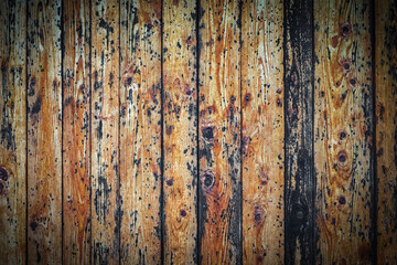 Old wooden fence with peeling black paint, vertical lines, background texture