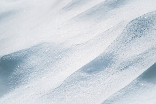 From above of smooth surface of white snow on sunny winter day as background