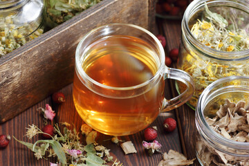 Herbal tea and jars with dry homeopathic herbs: chamomile, linden, calendula, burdock, rosehips and flowers, closeup, copy space, naturopathy and natural medicine concept