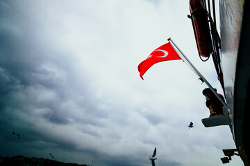 Fototapeta na wymiar Flag of Turkey on the boat and cloudy sky