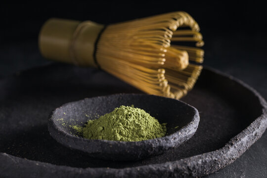 Dried tea leaves in heap on plate with chasen for tea ceremony