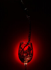Fototapeta na wymiar Sirviendo vino tinto, splash de vino en copa