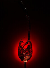 Sirviendo vino tinto, splash de vino en copa