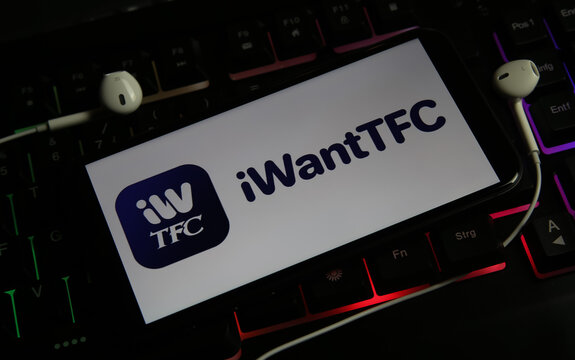 Viersen, Germany - March 1. 2021: Closeup of smartphone screen with logo lettering of online tv and movie streaming service iwanttfc on illuminated computer keyboard