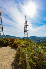 An electric power line support pole on a mountain top in the open air on a sunny summer day