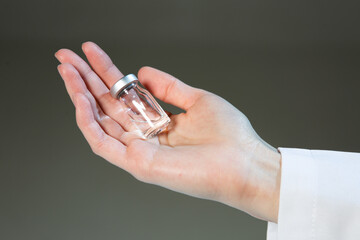 COVID-19 vaccine for immunization. Hand of doctor with transparent vial, close up. Healthcare and vaccination