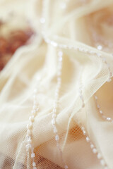 Fototapeta na wymiar elegant light pastel fabric with embroidery beads, aesthetic background