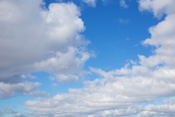 Naklejka na ściany i meble white clouds against a blue March sky, sunny day