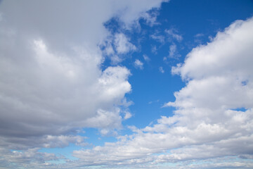 white clouds against a blue March sky, sunny day