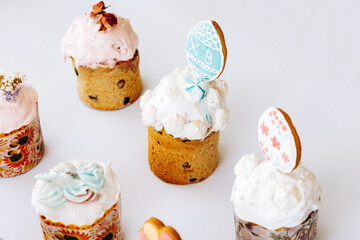 Set of Easter cakes decorated with cookies, bize and flowers. Homemade Easter baking in forms with ornaments on a white background