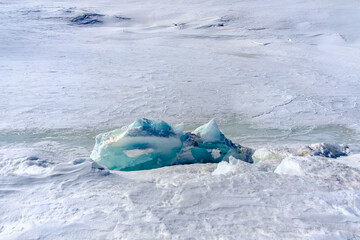 Türkisblaue Eisgebilde auf zugefrorenem Bergsee