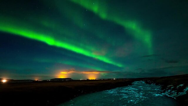 Vivid green Northern lights over Thjorsa river in south Iceland - time lapse video