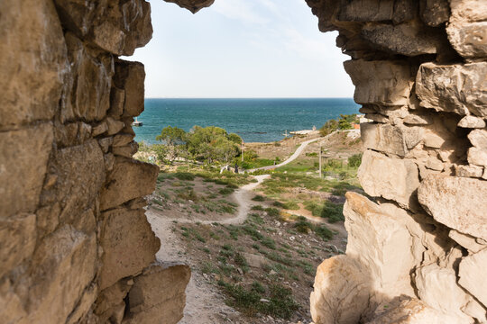 View from the window of the Krisko defensive tower of the medieval fortress of Kafa on the shore of the Gulf of Feodosia. There is path to the Black Sea