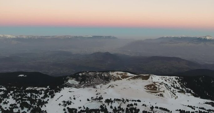 Chamrousse France Alpine landscape during cold morning sunrise showing sky gradient colors, Aerial flyover shot
