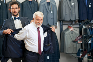 Father and son picking up suits in store.