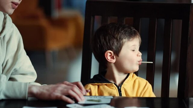 little boy learns words from cards under the ABA therapy program at home at the table