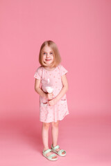 little girl with milk on a pink background