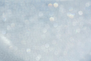 Glittering sparkles on a gray background. Spots and circles in blur. Abstract background for design. Horizontal format. Place for text