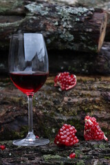 Pomegranate fruit and a glass of wine on the wood