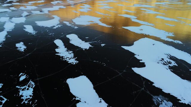 Transparent frozen ice, aerial drone. Arctic circle lake's frozen solid surface, vulnerable to climate change. A global warming tipping point.