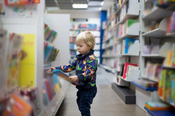 Adorable little boy, sitting in a book store