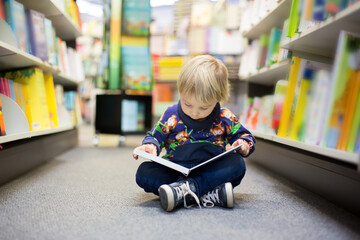 Adorable little boy, sitting in a book store