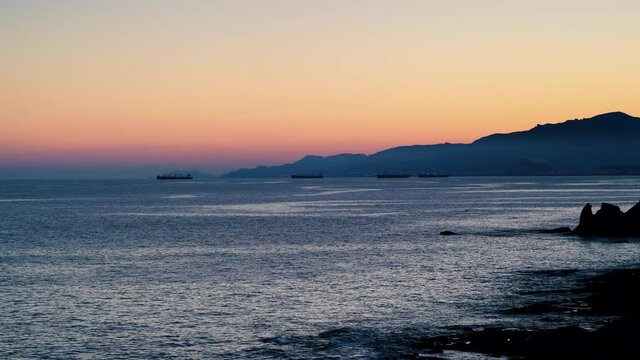 Sea coast with cargo container industrial ships anchored waiting for entering Carboneras port in Almeria, Spain. Mediterranean coastline near Villaricos village.