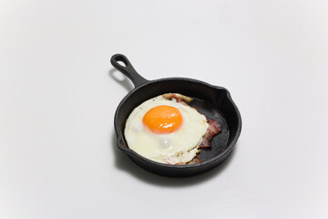 フライパンにのせたベーコンエッグ