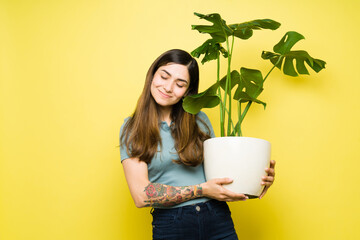 Cute young woman enjoying her beautiful plants