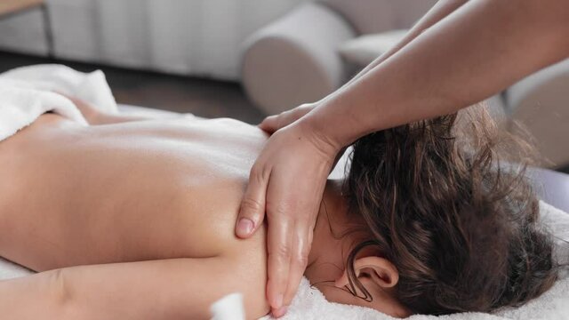 Womman lying on spa bed get back massage treatment scrub with spa salt and essential oil skincare from massage therapist at beauty salon. Wellness body massage and spa concept