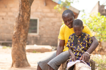 african man tutoring a child outside
