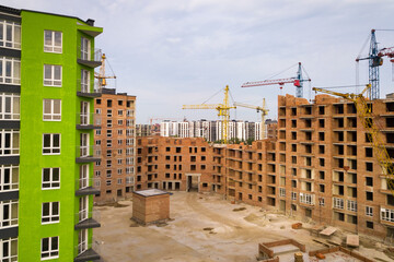 Aerial view of city residential area with high apartment buildings under construction.