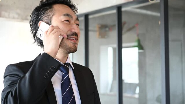 外出先で部下に指示を出す管理職風の日本人男性の動画 フィックス