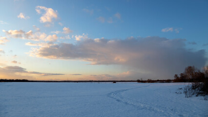 Sunset in the winter field. Snow road. Winter field panorama.